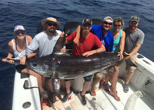 Charley and his family showing off the big game they caught in the Cozumel island.
