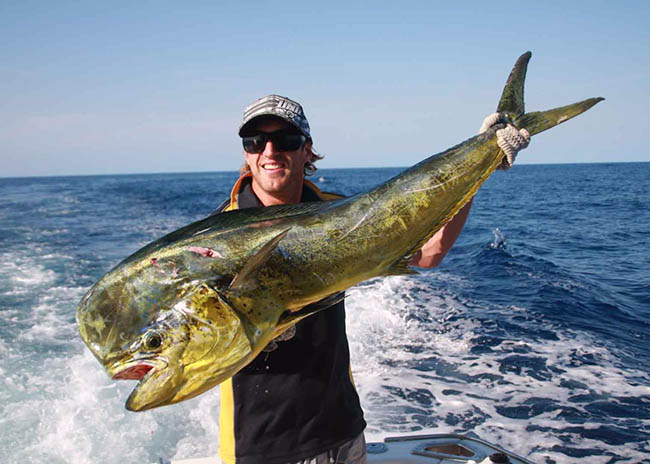 Marcus very excited showing his catch in the fishing charter.