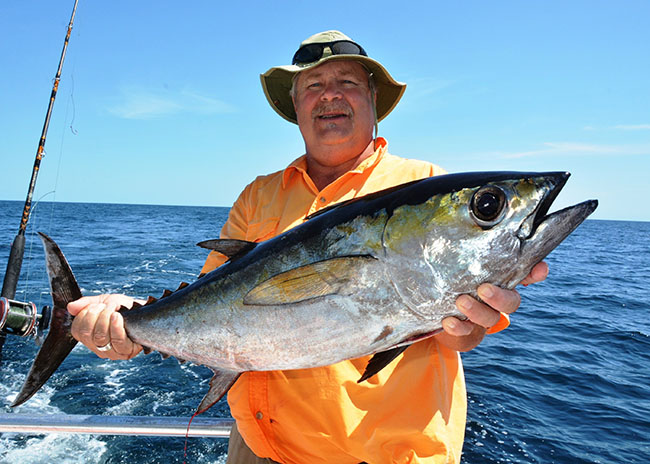 Israel showing his catch on a sunny fishing day in Cozumel.