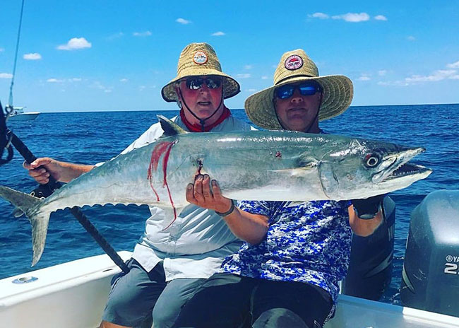 Michael holding up his catch after a great fishing day with his friends.